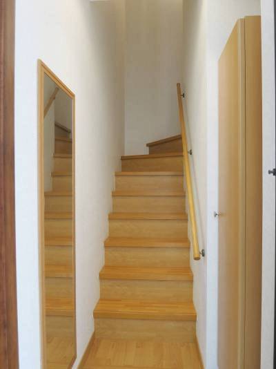 １階玄関から階段を上がって２階へ。玄関には姿見ミラー。