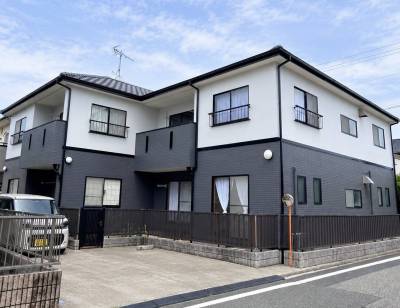 白&times;ダークグレーの外壁が印象的な、落ち着いた佇まい。