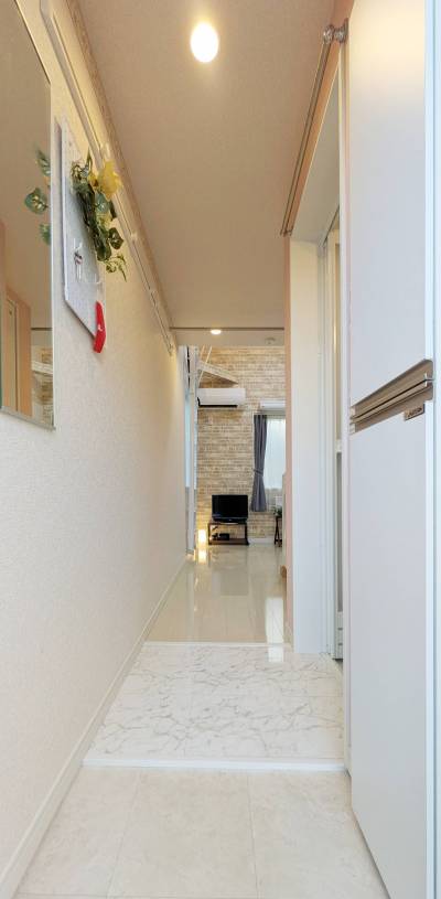 玄関入ってすぐ．鏡，有孔ボード，コート掛けが便利．