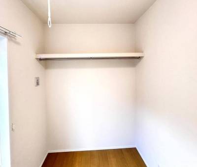 服をかけられて収納物が一目で分かるウォークインクローゼット