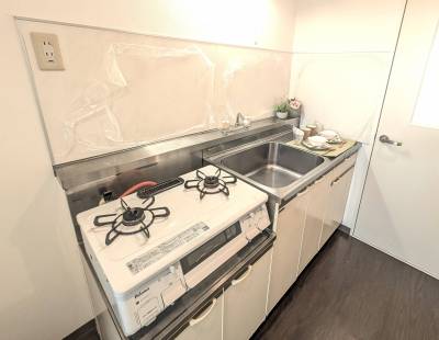 2口コンロ、大きなシンク、キッチンパネルがあるキッチン