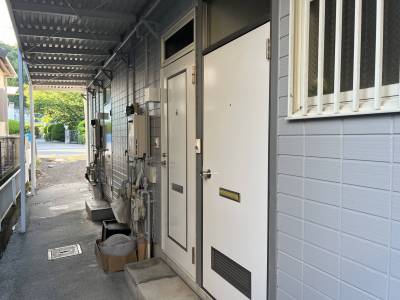 ライトグレーの外壁に白色のドアがおしゃれ♪