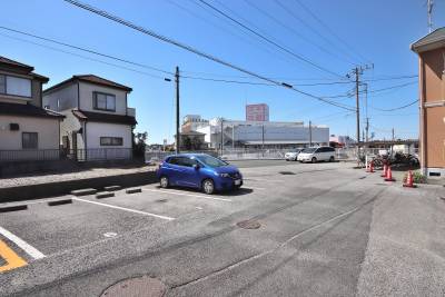 105号室南側の駐車場。青い車の向こう側に駐車スペースあり