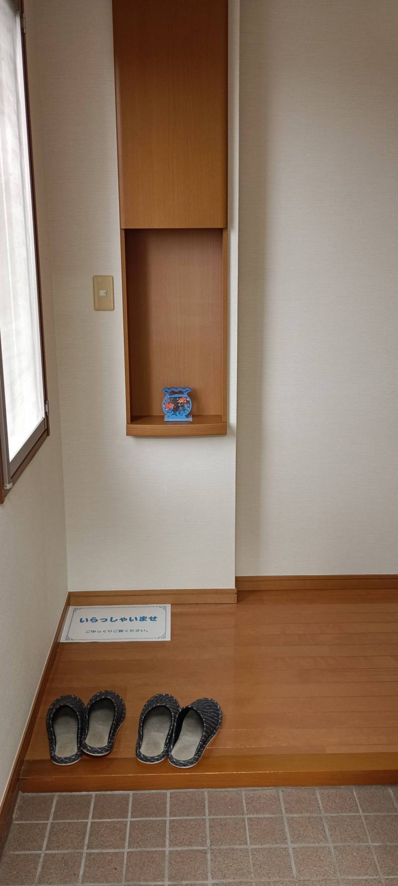 飾り棚がある玄関、窓があるので暗くないです。