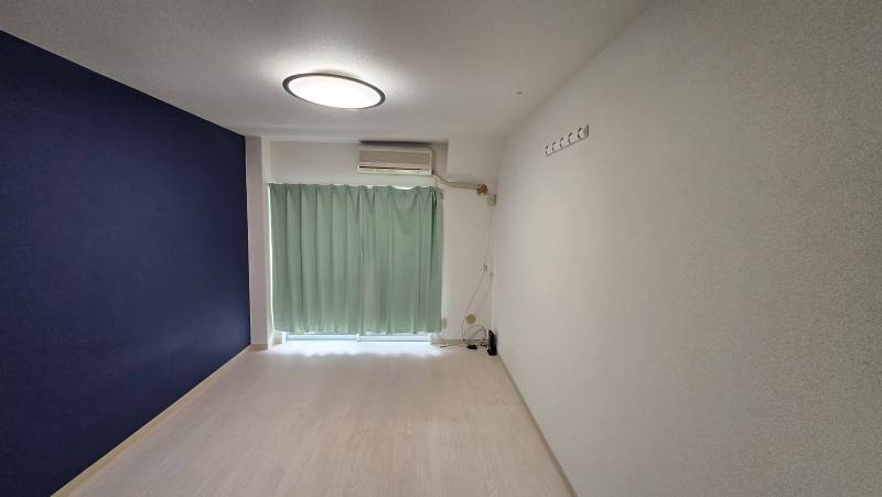 キッチンからバルコニー側を見た写真。カーテン、照明付き