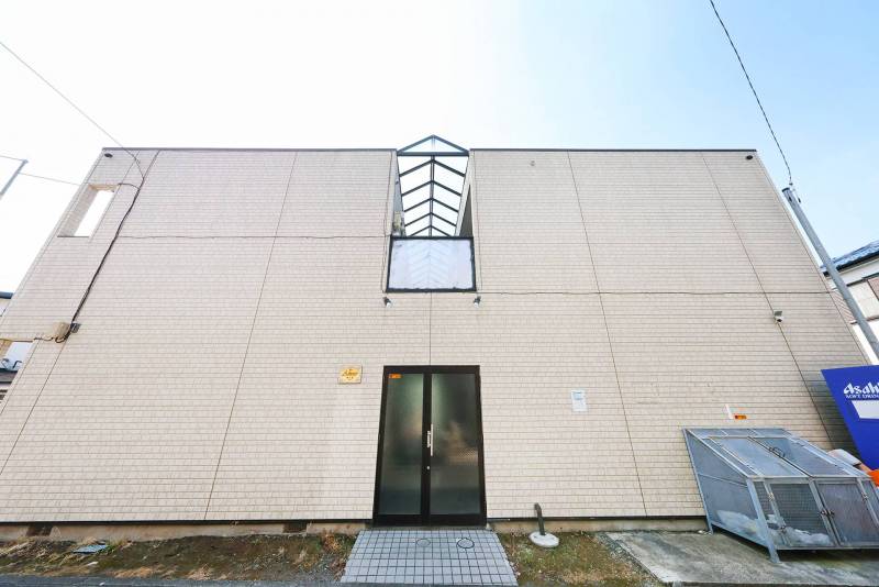 正面玄関の写真です。ゴミ置き場、自動販売機設置されています