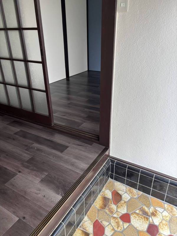 レトロな玄関タイルと玄関横小部屋の奥ブルーの壁のアクセント
