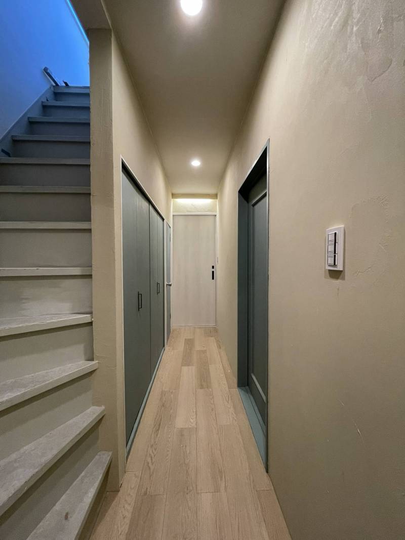 玄関から廊下の壁は、漆喰とダウンライトで仕上げました。