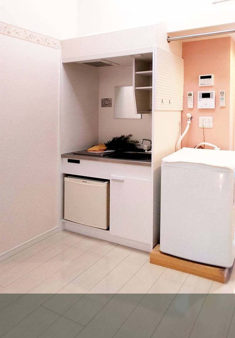 コンパクトながら機能的なキッチン．洗濯機上のバーも便利．