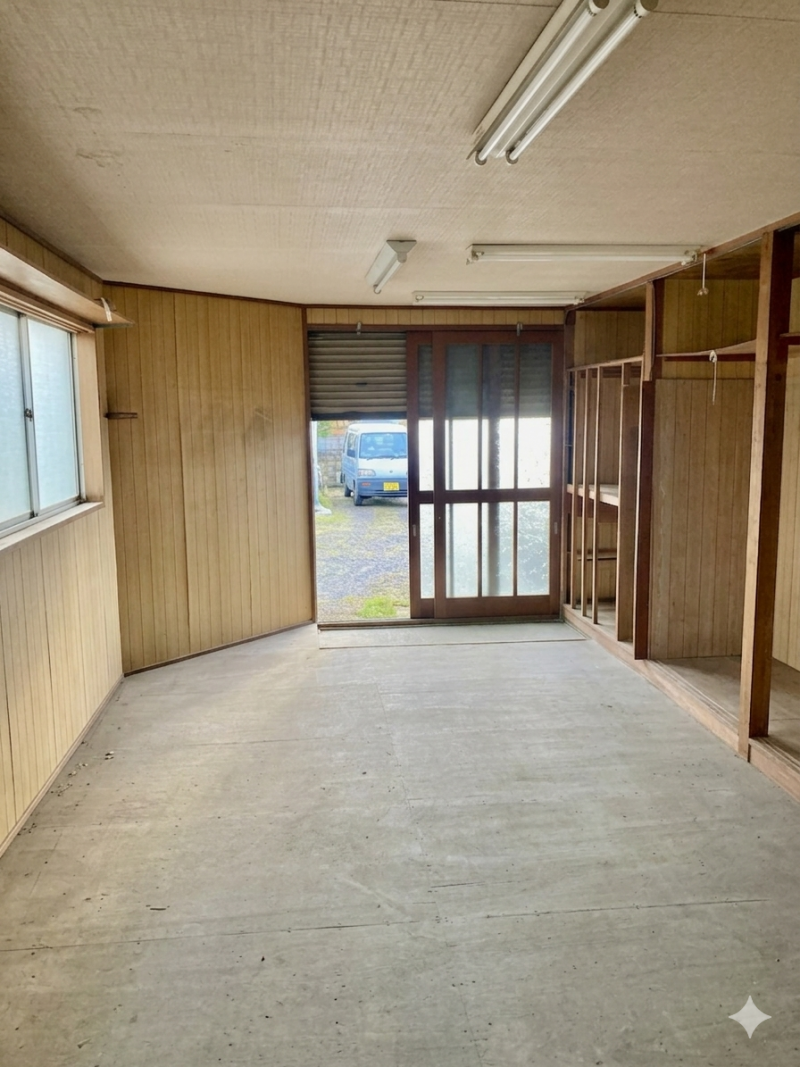 一階倉庫内部。窓がありあかるく、収納棚もあり。床は板張り。
