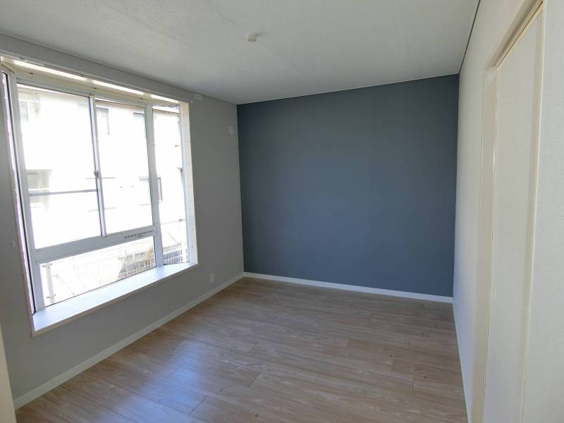 大きな出窓の落ち着いた洋室