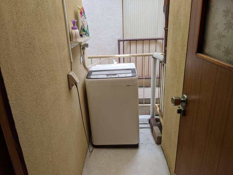 屋外ベランダに洗濯機が付いています