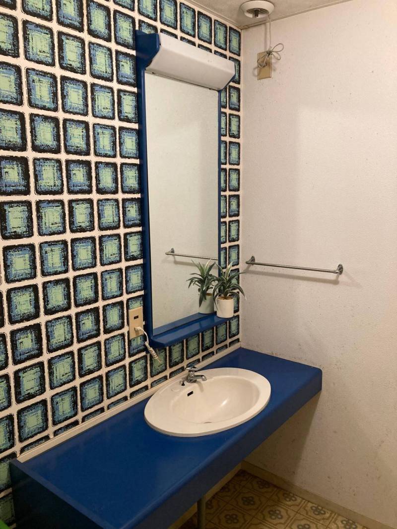 洗面所です。レトロ感のある壁紙になっています。