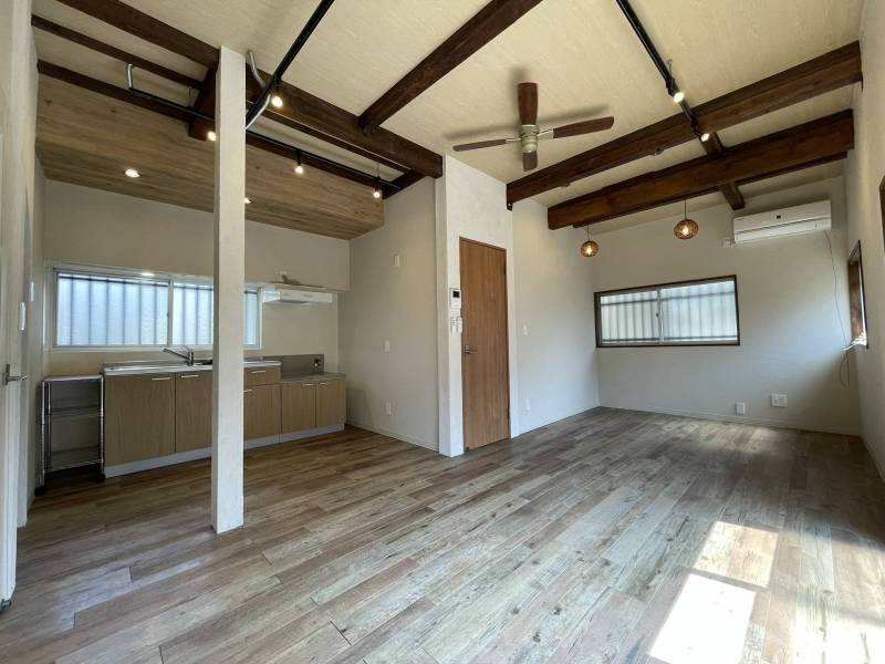 ドアを開けると、太い梁が並ぶ高天井の広いリビング。