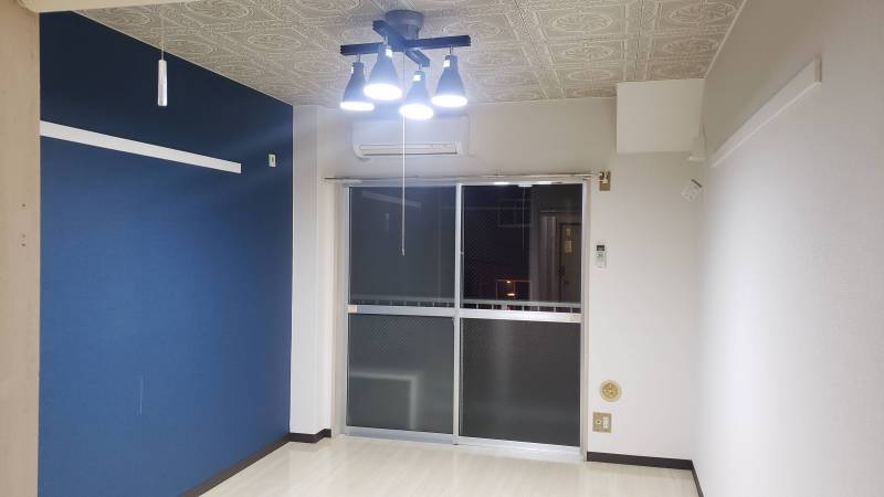 ブルーのアクセントクロス、黒のお洒落な照明付き