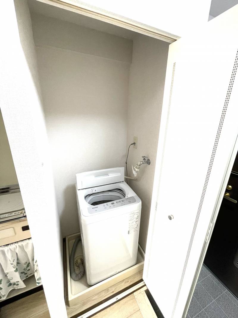 洗濯機は玄関ホールの専用置き場にスマートに収納。