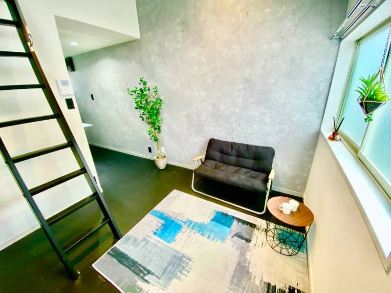 モルタル調の壁紙、黒なフロアタイルで高級感がある床