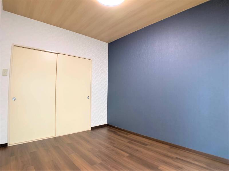 6帖洋室。鮮やかなアクセントクロス。光が差し込む室内。