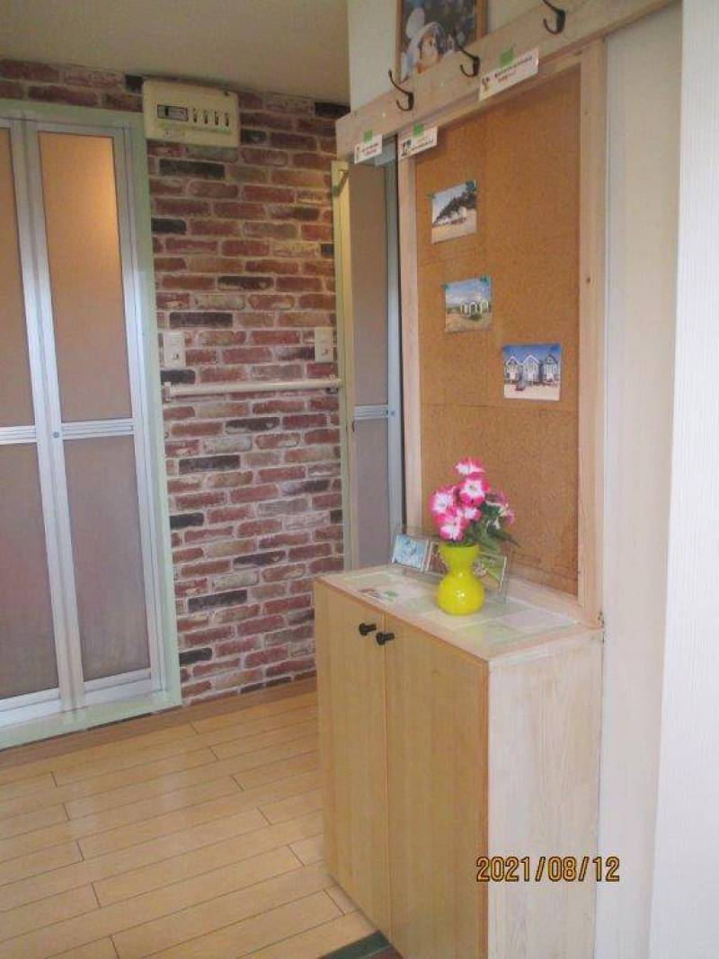 玄関。下駄箱とコルクボード、フックがあります。