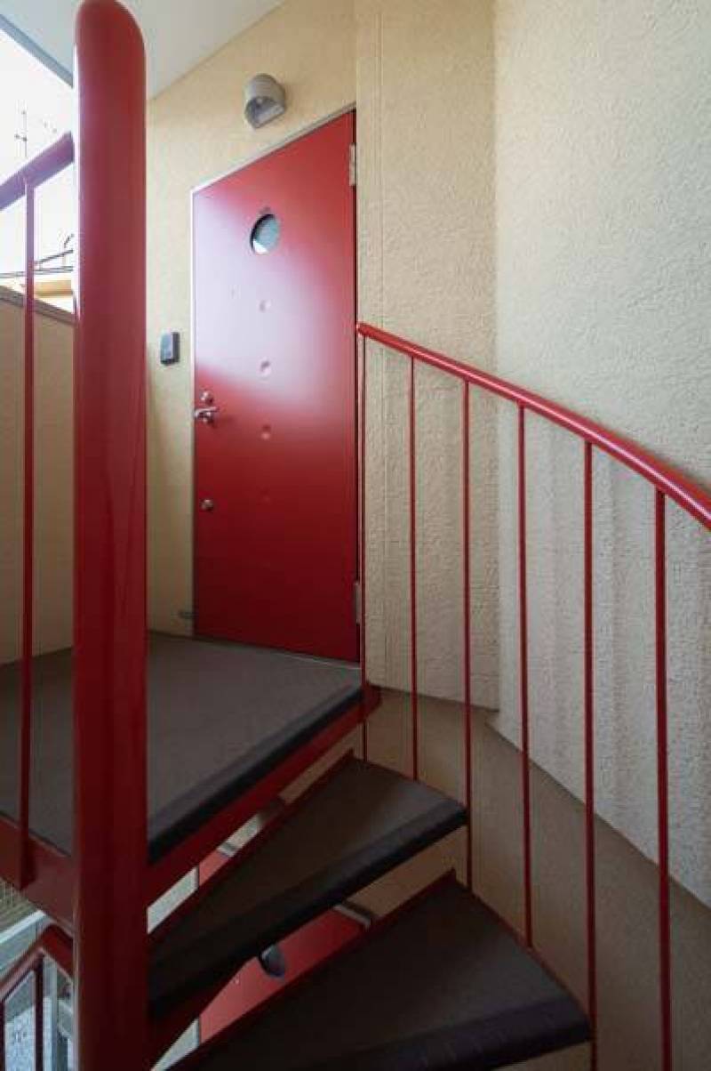 部屋へ上る赤い塗装の階段と玄関ドア